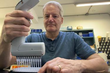 Donald Van Doornik looking at the camera while processing samples