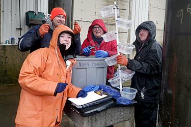 Group of scientists that study crab growth next to scientific equipment