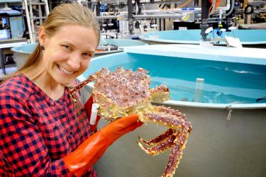 Woman holding crab near lab pools 